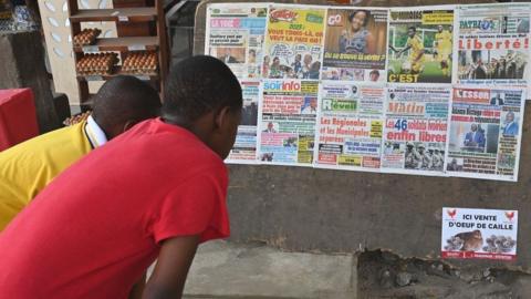 People read the headlines of newspapers in Abidjan on 7 January 2023, after the release of 46 Ivorian soldiers who had been arrested in July 2022 in Mali