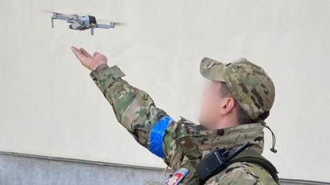 A Ukrainian soldier uses a small consumer drone