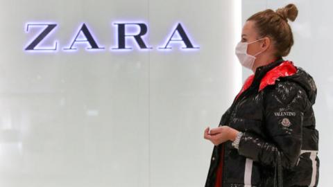 Young woman in a medical mask by the Zara store at the Aviapark Shopping Mall in Moscow