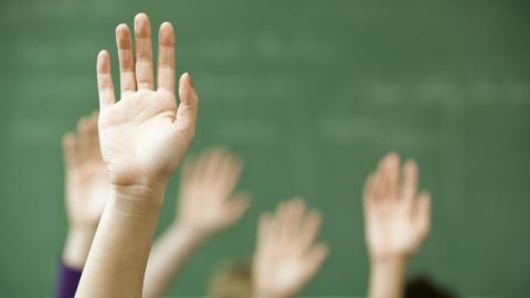 Raised hands in a classroom