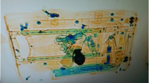 A scan image of inside the suitcase with what looks like a grenade