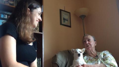 Kelly Dixon chats with Gaynor Lynch at her home as she pets Pudding, a Chihuahua