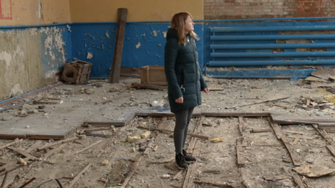 Mariya surveys a destroyed gym hall