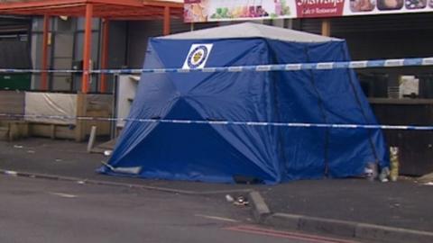 Police tent outside a row of shops