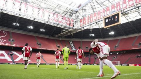 Ajax players walk on to the field at an empty Johan Cruijff ArenA