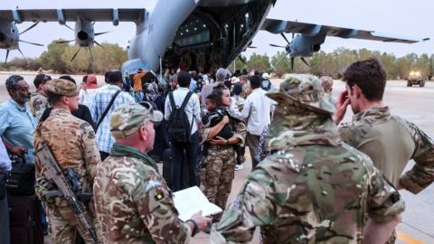 British nationals wait to board an RAF aircraft, during the evacuation to Cyprus, at Wadi Seidna Air Base in Sudan