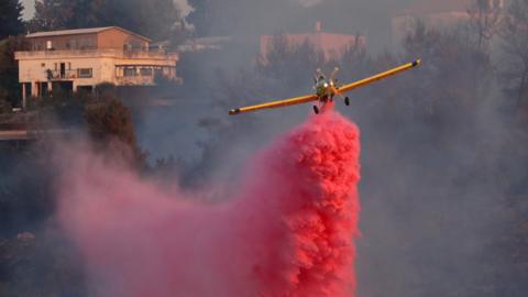 Israeli firefighting plane drops flame retardant at the village of Givat Yearim, near Jerusalem (16 August 2021)