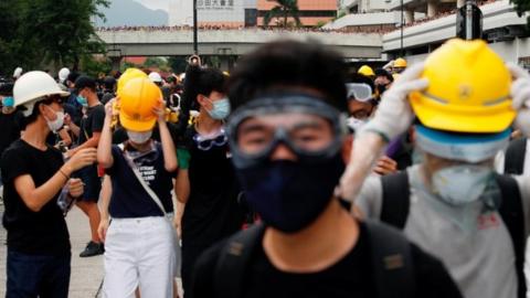 Hong Kong protesters dressed in masks and hats