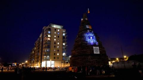 The bonfire is pictured before the burning, with the apartment building behind