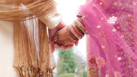 Muslim wedding - close up of bride and groom holding hands
