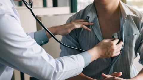 Doctor using a stethoscope to listen to the heartbeat of a patient