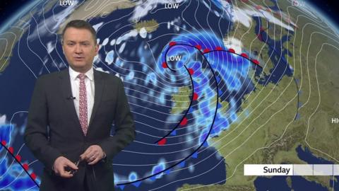 Matt Taylor stands in front of a weather map of the UK