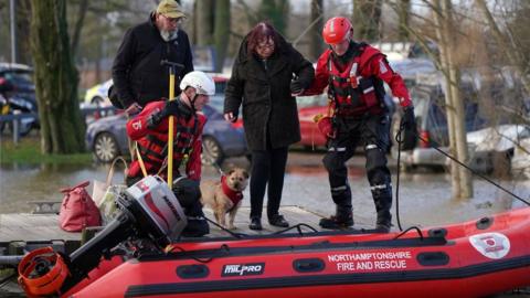 A woman is rescued from flood water in Northampton