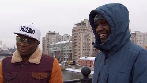 Steve in a white baseball cap and Franklin in a blue thick jacket on a bridge in snowy Moscow