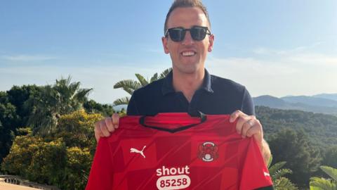 Harry Kane poses with a Leyton Orient shirt