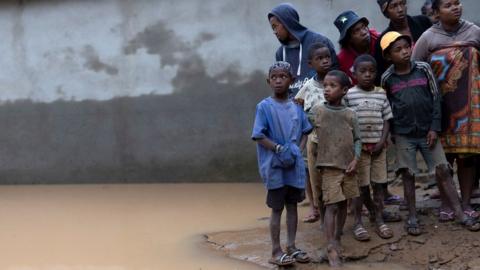 Locals stand next to a flooded area, as Cyclone Batsirai sweeps inland, in Fianarantsoa, Madagascar, February 6, 2022