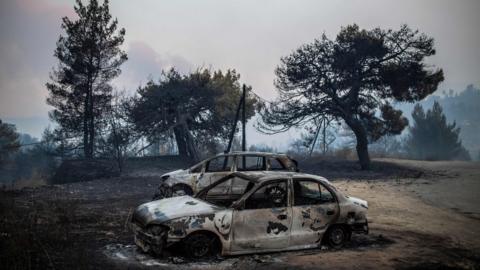 Abandoned, blackened cars on the island of Evia, Greece