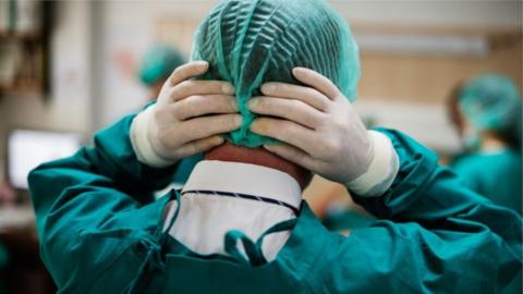 Surgical doctor with hands on his head