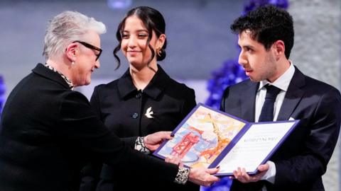 Leader of the Nobel Committee Berit Reiss-Andersen presents Ali and Kiana Rahmani, children of Narges Mohammadi, an imprisoned Iranian human rights activist, with the Nobel Peace Prize 2023, as they accept the award on behalf of their mother at Oslo City Hall, Norway December 10, 2023