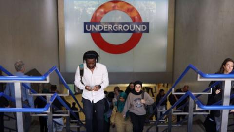 Passengers leave an Underground station