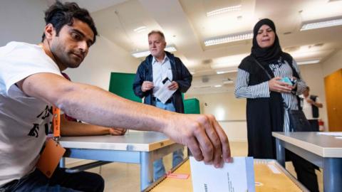 An electoral counsellor in Malmo casts a vote during the Swedish general elections on September 9, 2018