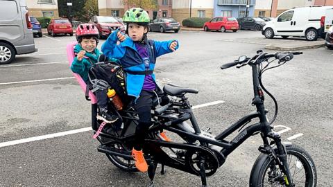 Two children on an e-cargo bike