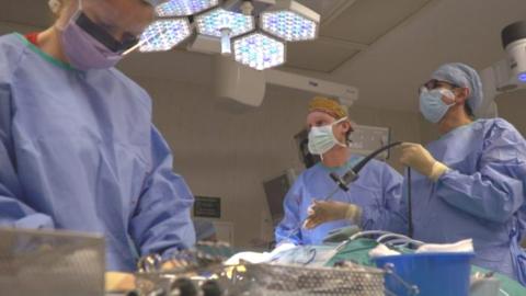 Surgeons using robots