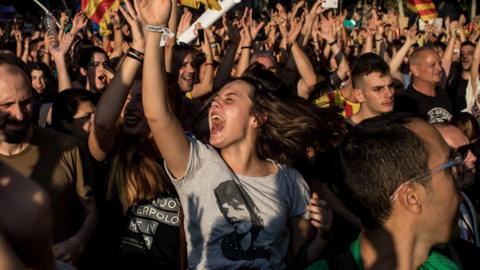 People dance and sing songs as thousands of citizens gather in Plaza Universitat during a regional general strike to protest against the violence that marred Sunday's referendum vote on 3 October 2017 in Barcelona, Spain