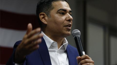 Robert Garcia holds a microphone.