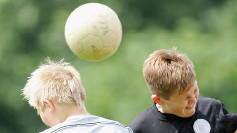 boy heading football