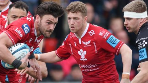 Johnny Williams of Scarlets tries to break free as Aaron Wainwright (R) moves in