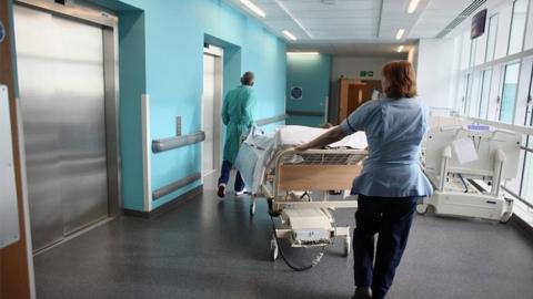 Nurses wheels patient on a trolley