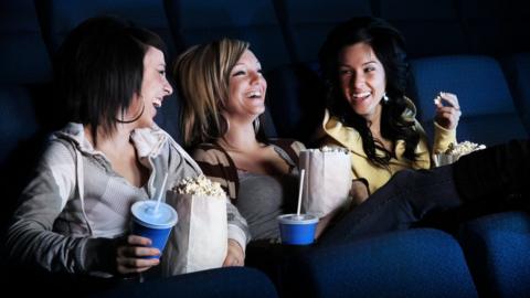 Young women at the cinema laughing