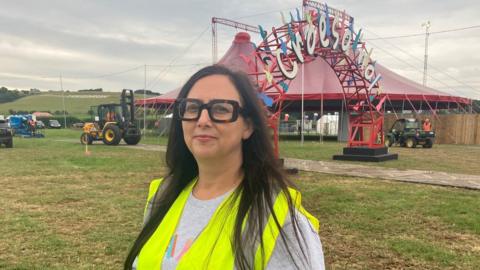 Betsan Moses standing in front of the welcome arch and a tent at last year's National Eisteddfod