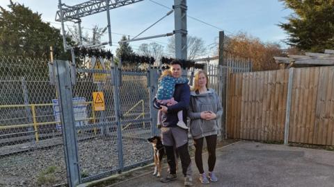 David White and family by entrance to railway section near their home