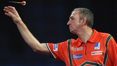 Richie Burnett throws a dart on the oche