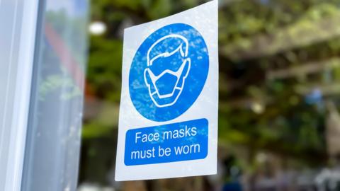 A sign asking people to wear masks
