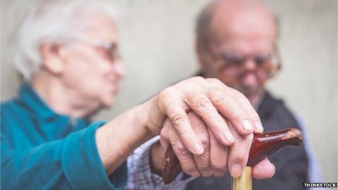 elderly couple holding hands