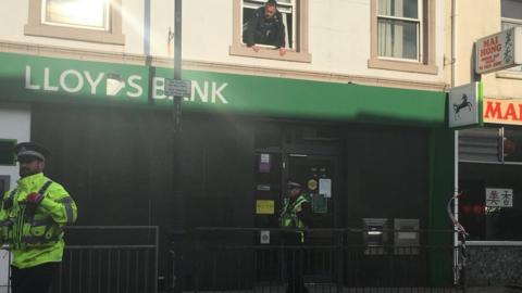 Police officers survey the robbed bank