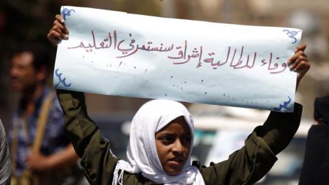 Demonstrating outside the UN office in Sanaa, a girl holds a banner saying: "We will continue in our education"