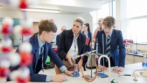 Teacher with pupils in science lab