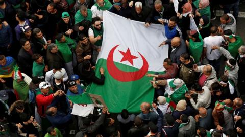 Algerians protesting with a flag