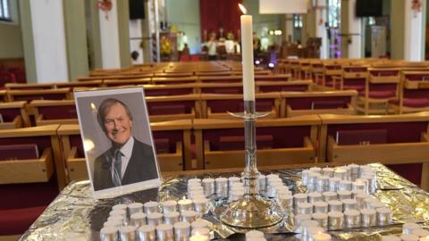 A photo of Sir David Amess at a vigil for him