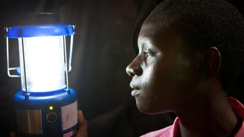 Person looks at solar powered lamp