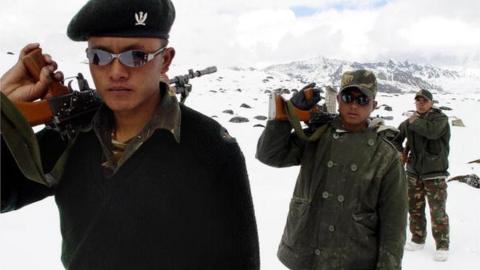 Indian Army soldiers of the Gorkha Regiment carry weapons as they walk through snow, along the India-China border at the height of 16,000ft near Tawang,some 580km from Itanagar, state capital of Arunachal Pradesh,