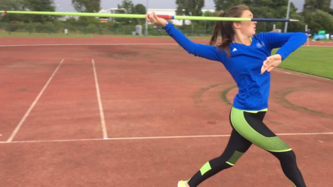 Molly Smith throwing a javelin at an athletics track in Merthyr