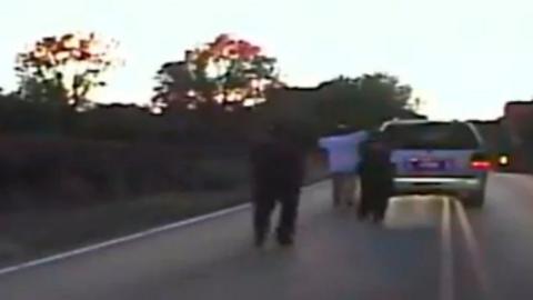 Terence Crutcher holding his hands in the air.