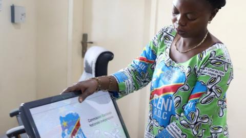 DRC election official prepares a voting machine