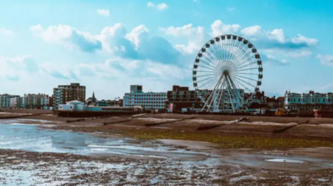 An image of Worthing seafront, featuring a big wheel.