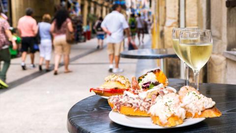 Tapas and wine in a bar at a table on a street in Spain
